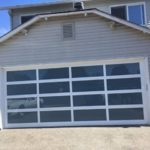 A glass garage door with a reflect of white car